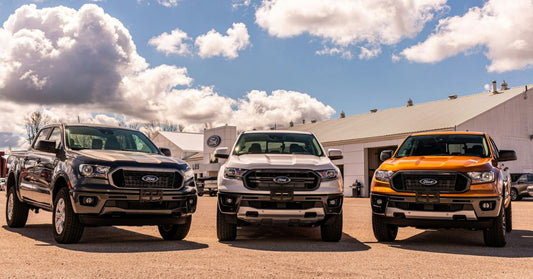 Three Ford Ranger pickup trucks parked in front of a dealership under a partly cloudy sky, representing rugged reliability and common engine troubleshooting topics.